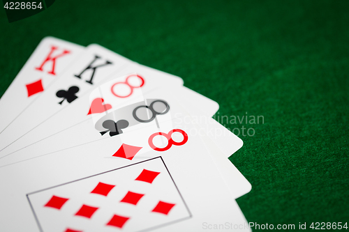 Image of poker hand of playing cards on green casino cloth