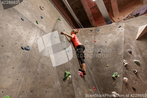 Image of young woman exercising at indoor climbing gym