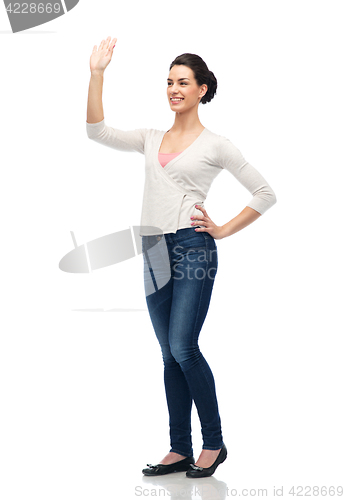 Image of happy smiling young woman waving hand over white