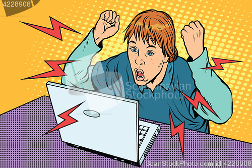 Image of Angry teenager sitting at computer laptop