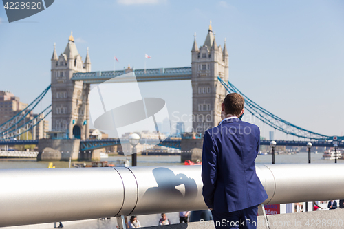 Image of British businessman talking on mobile phone outdoor in London city, UK.