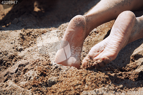 Image of Legs of woman laying at the beach