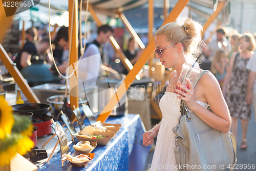 Image of Woman buying meal at street food festival.