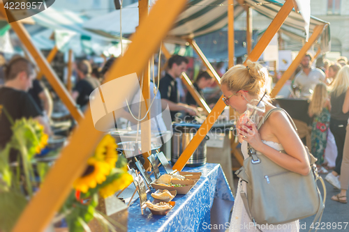 Image of Woman buying meal at street food festival.