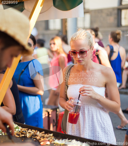 Image of Woman buying meal at street food festival.