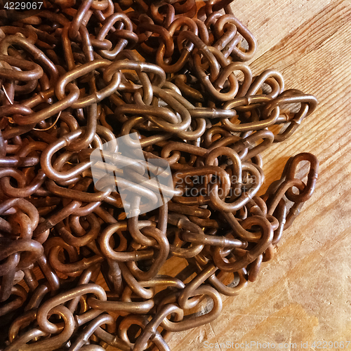 Image of Rusty metal chains on wooden background