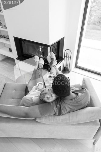 Image of Young multiethnic couple  in front of fireplace