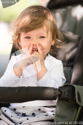 Image of baby girl sitting in the pram