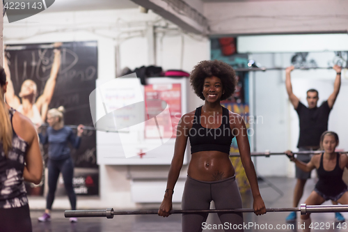 Image of black woman lifting empty bar