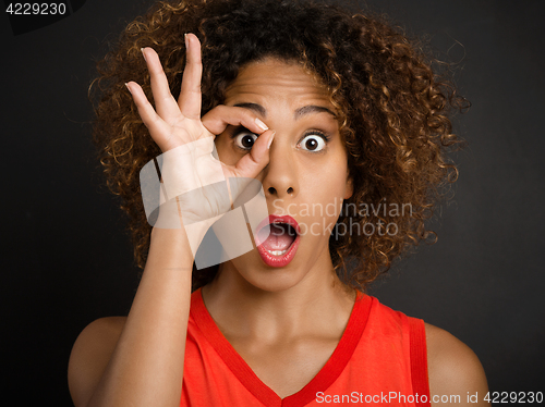 Image of Beautiful woman looking through her fingers