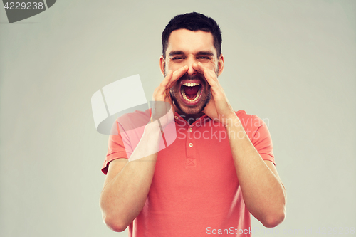 Image of angry shouting man in t-shirt over gray background
