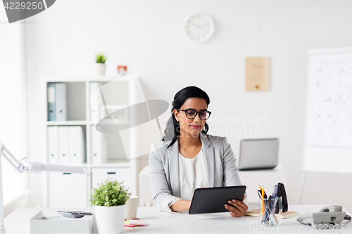 Image of smiling businesswoman with tablet pc at office
