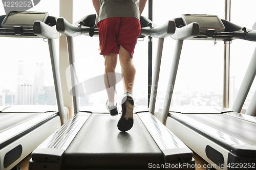 Image of man exercising on treadmill in gym