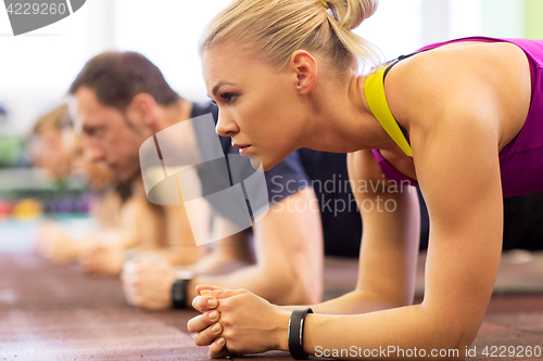 Image of close up of woman at training doing plank in gym