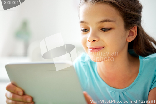 Image of close up of smiling girl with tablet pc at home