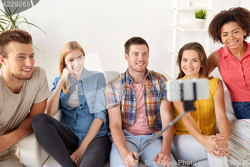 Image of happy friends taking selfie by smartphone at home