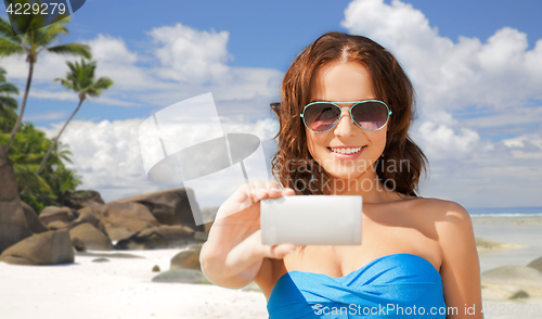 Image of woman in swimsuit taking selfie with smatphone