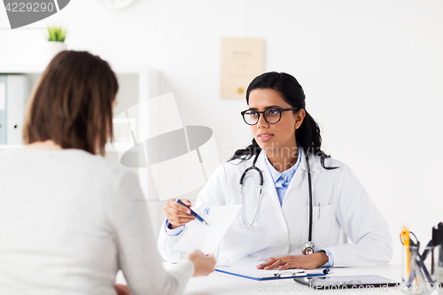 Image of doctor with clipboard and woman at hospital