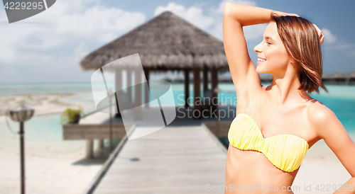 Image of happy woman in bikini swimsuit on tropical beach