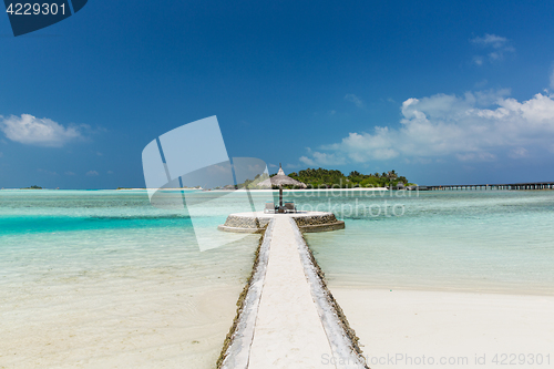 Image of patio or terrace with palapa and sunbeds on beach