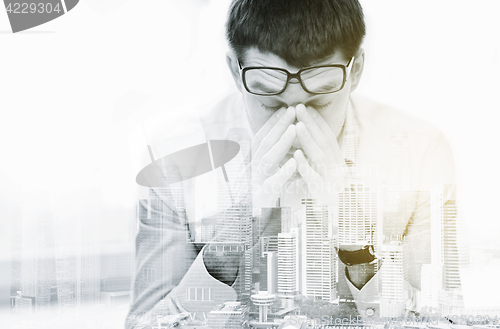 Image of tired businessman with eyeglasses at office