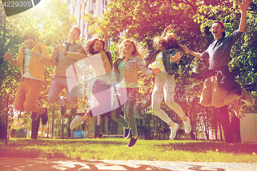 Image of happy teenage students or friends jumping outdoors