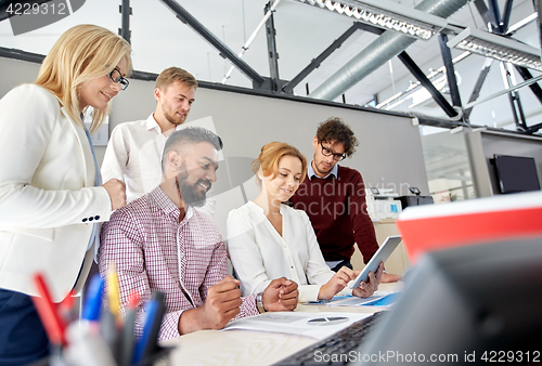 Image of business team with tablet pc and papers at office