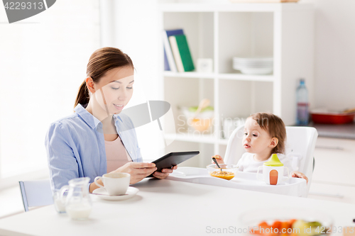 Image of happy mother and baby having breakfast at home