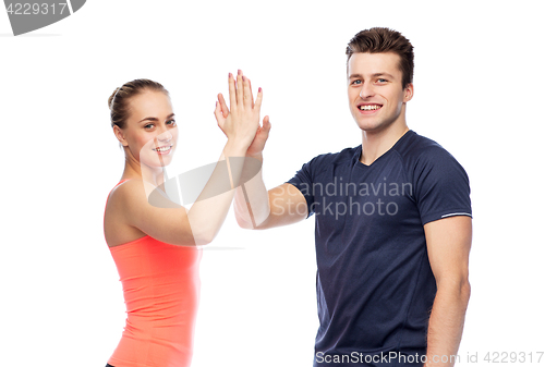 Image of happy sportive man and woman making high five