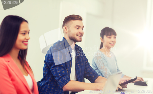 Image of happy creative team or students working at office