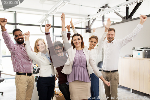 Image of happy business team celebrating victory at office
