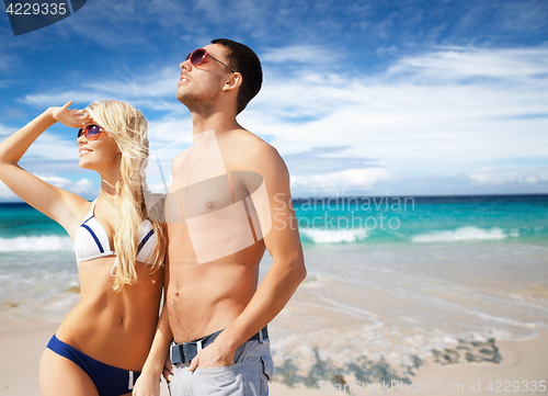 Image of happy couple in sunglasses on exotic summer beach