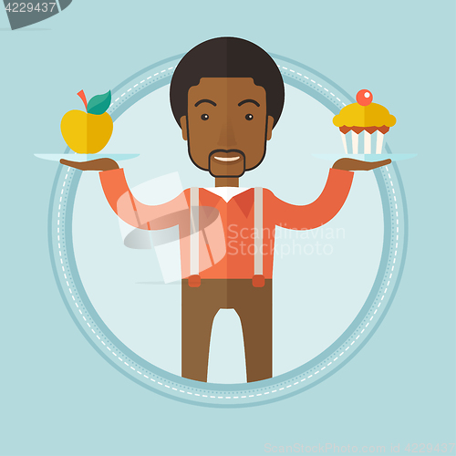 Image of Man choosing between apple and cupcake.