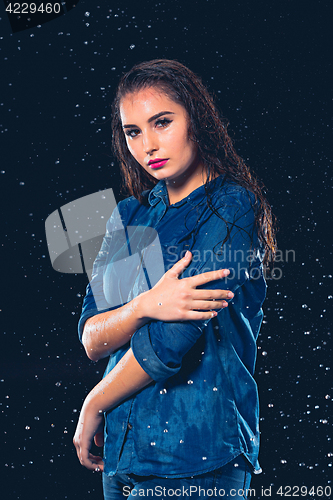 Image of Young beautiful woman under splash of rain