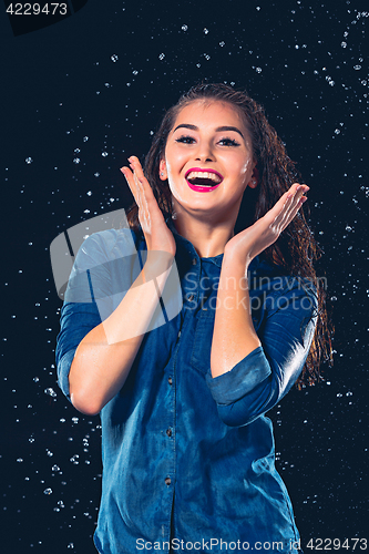 Image of Young beautiful woman under splash of rain