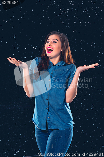 Image of Young beautiful woman under splash of rain