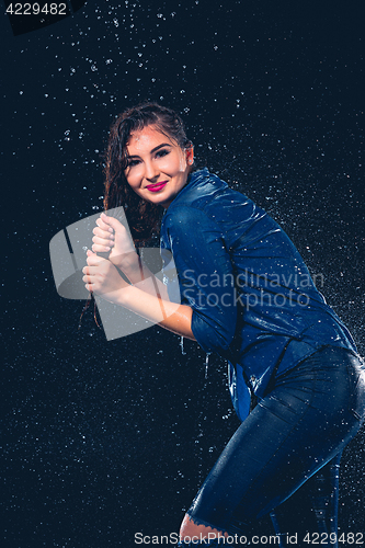 Image of Young beautiful woman under splash of rain