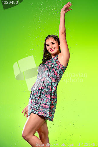 Image of Young beautiful woman under splash of rain