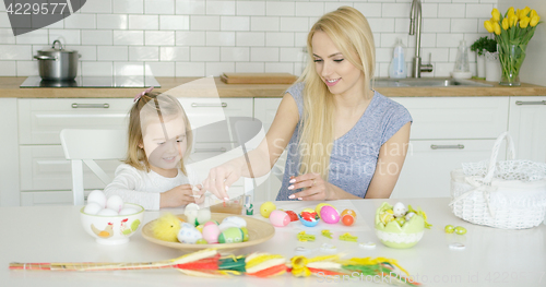 Image of Charming mother and daughter coloring eggs