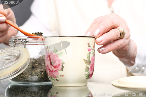 Image of Grandma&#39;s herbs for colds. Brew of herbs, herbal medicine. Elderly woman burns herbs 