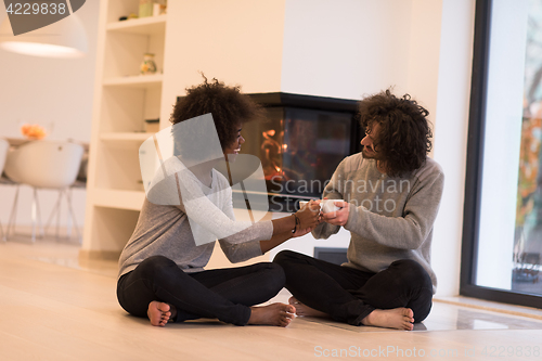 Image of multiethnic couple  in front of fireplace