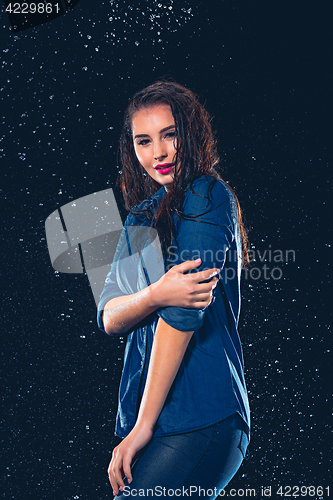 Image of Young beautiful woman under splash of rain