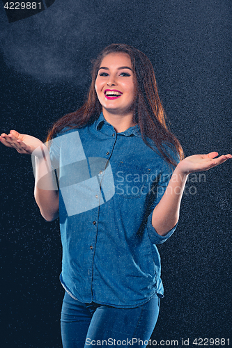 Image of Young beautiful woman under splash of rain