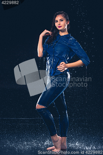 Image of Young beautiful woman under splash of rain