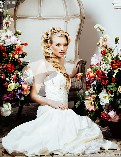 Image of beauty young blond woman bride alone in luxury vintage interior with a lot of flowers