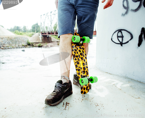 Image of young handsome real hipsrter guy bearded staying under the bridge extreme with leopard skateboard, lifestyle people concept 