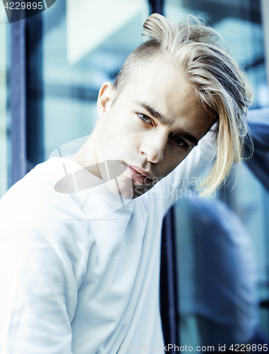Image of young modern hipster guy at new building university blond fashion hairstyle having fun, lifestyle people concept 