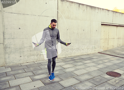 Image of man exercising with jump-rope outdoors