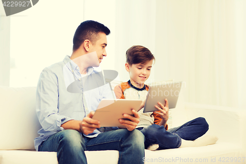 Image of happy father and son with tablet pc at home