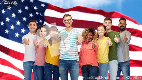 Image of happy people showing thumbs up over american flag